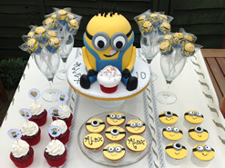 Despicable Me Cake and Cupcakes on a Party Dessert Table